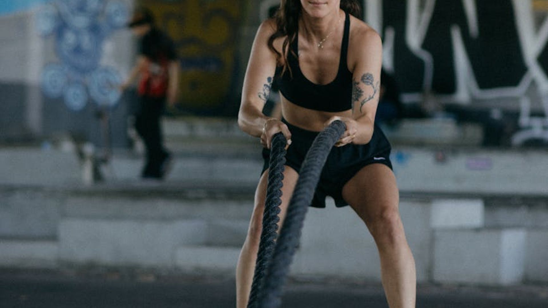 A person performing dynamic movement in a dark gym setting